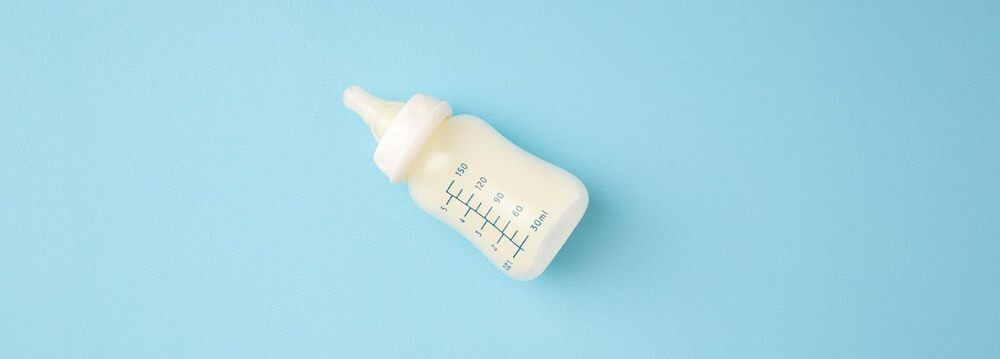 Baby bottle on blue table