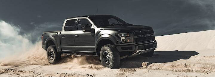 Black truck on sand dunes