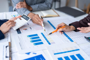 Business team analyzing financial data using calculator and documents